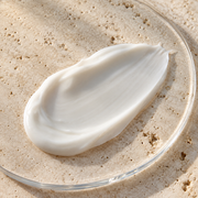 Soft white eye cream texture on a clear dish